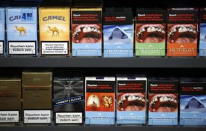 Cigarette boxes with an affixed, self-made cigarette label displaying graphic images and those with the original label are pictured in the shop of tobacconist and kiosk owner Schulzki in Berlin