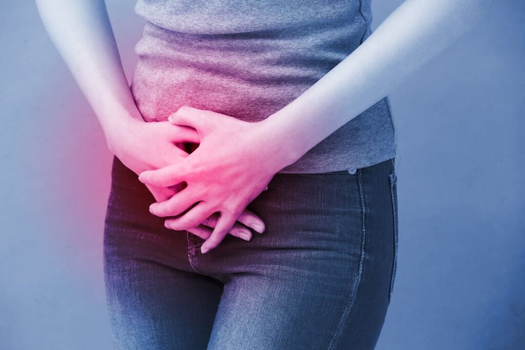 Illustrasjon av urinveisinfeksjon: En kvinne holder seg over nedre del av magen på grunn av smerter.